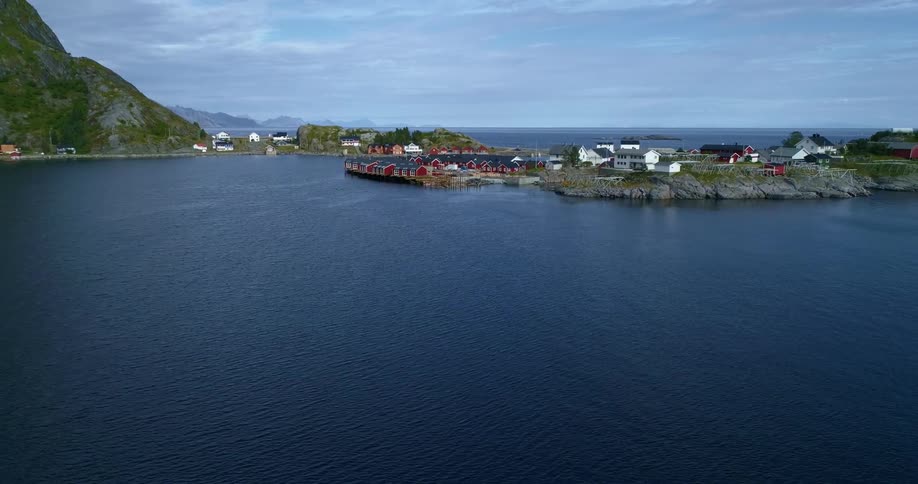 Wide view of a town on the edge of a body of water with hills