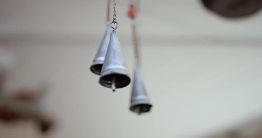 A breeze blowing through metal bells hanging on chains