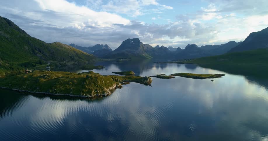Blue skies and fluffy clouds reflect onto a lake in a canyon in the countryside