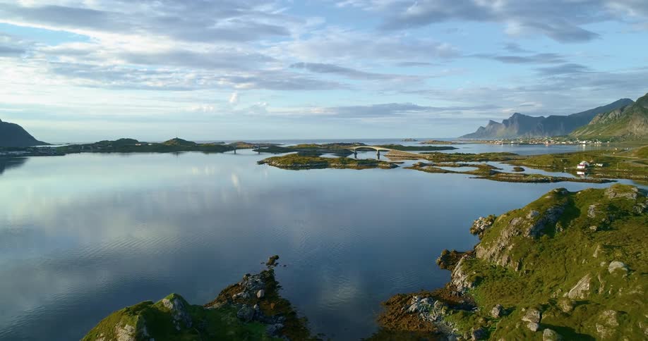 Aerial view of a body of water mountains and blue sky with clouds