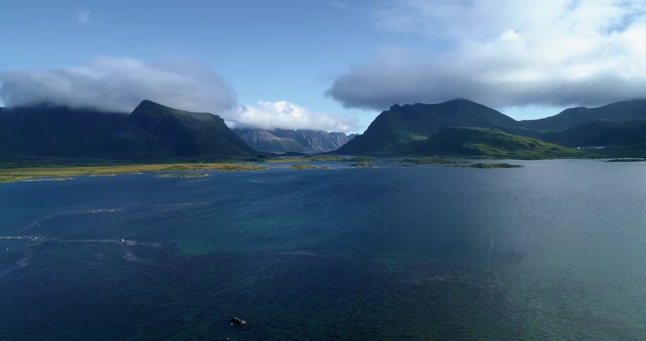 Calm waves move in the ocean near promontories covered with moss