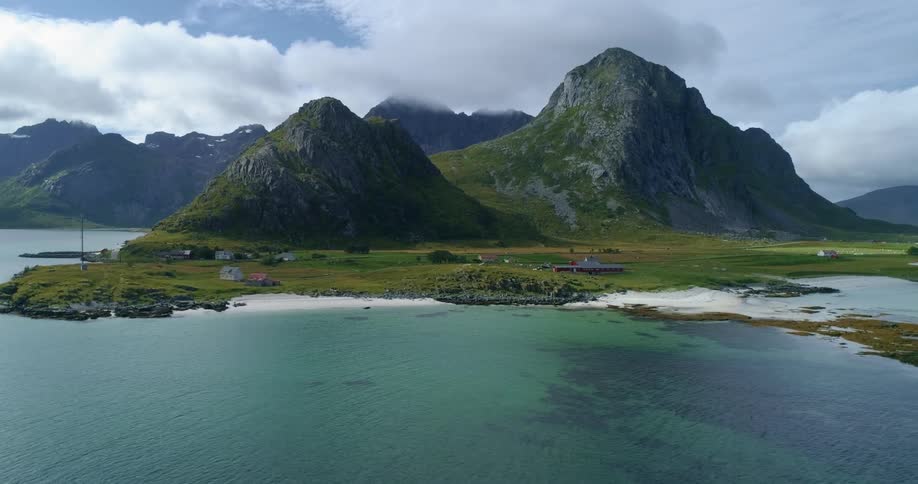 Aerial view of the bay next to a cloud covered mountain range on the coast