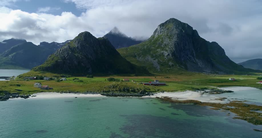 An aerial view of a mountain range in front of a lake