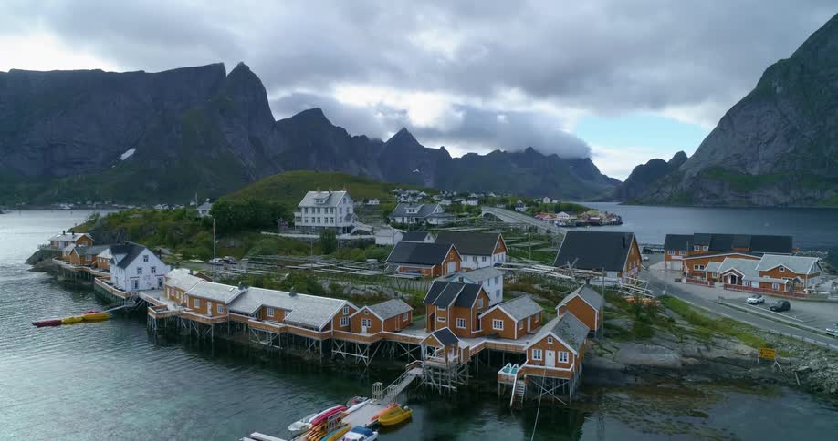 A small fishing town is surrounded by water and tucked between several mountains