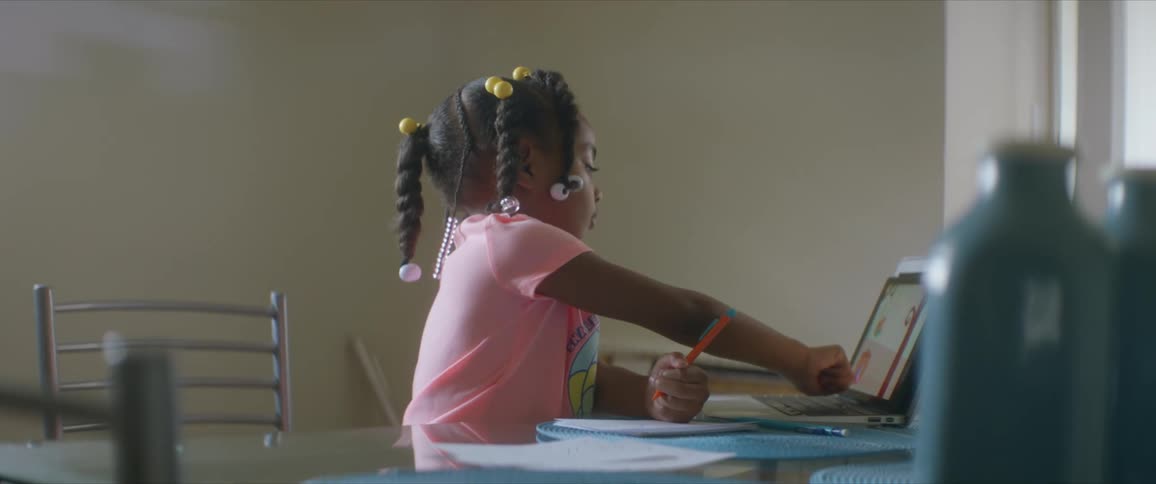 A young girl uses a laptop at home as she does school work
