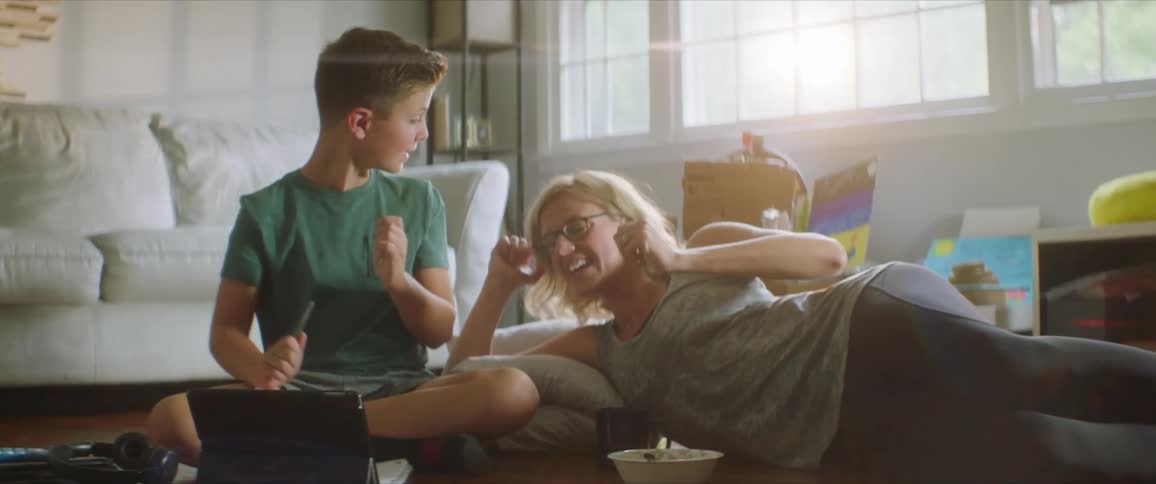 Mother and son having fun with each other sitting in the floor on the living room