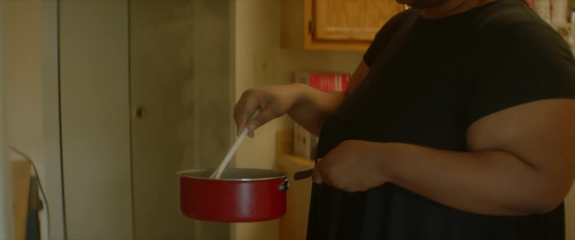 A woman stirs the hot contents of a pot
