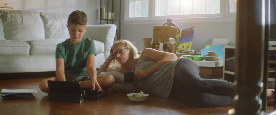 Mother and son sitting on the floor of the living room relaxing