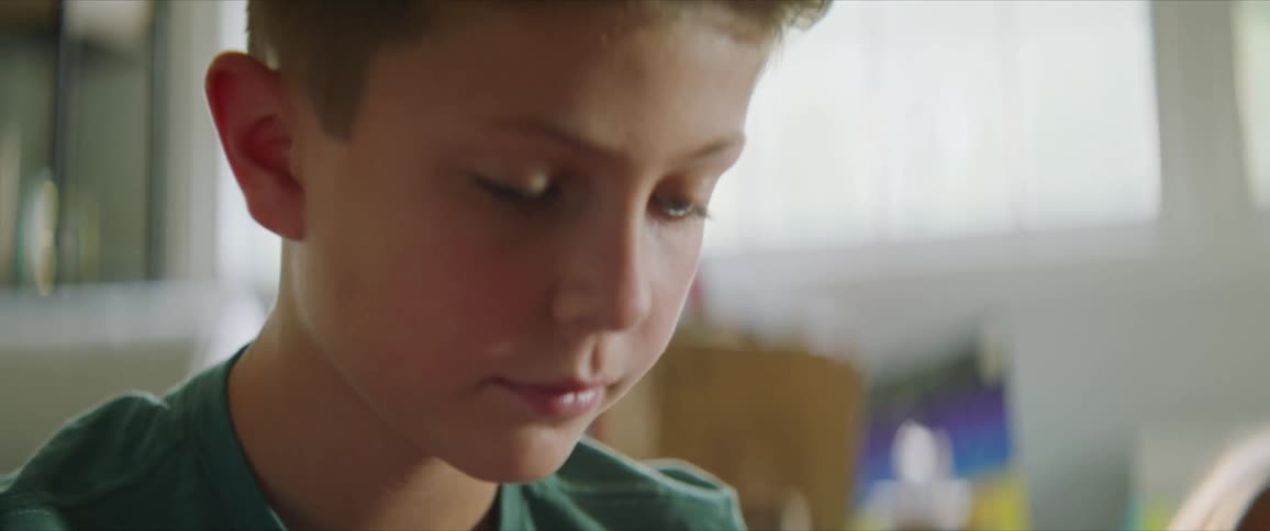 Boy talks to his mother while sitting on the floor in the living room at home