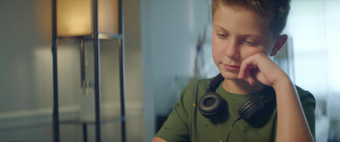 Boy with a green shirt and headphones uses a tablet