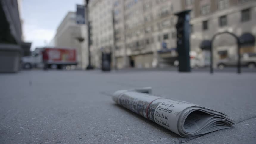 A newspaper on a sidewalk with a headline about a presidential election