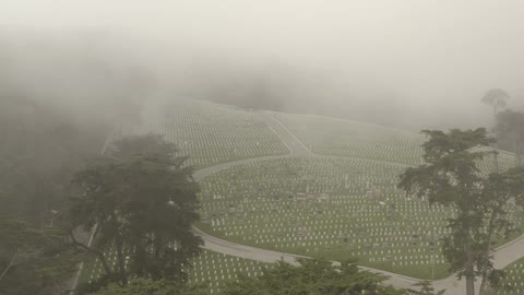Mist crawling in over an aerial view of a military graveyard