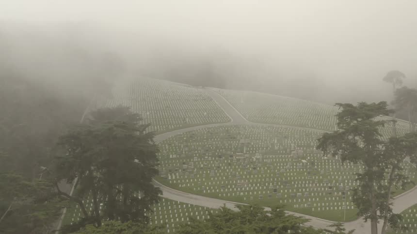 Mist crawling in over an aerial view of a military graveyard
