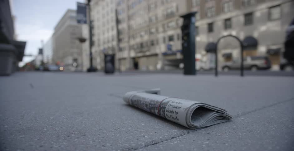 A newspaper lying on a city sidewalk in the daytime with front page headlines about the presidential election