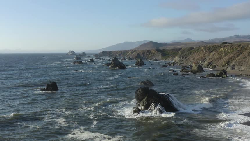 Seaside coastline as waves roll in among the rocks