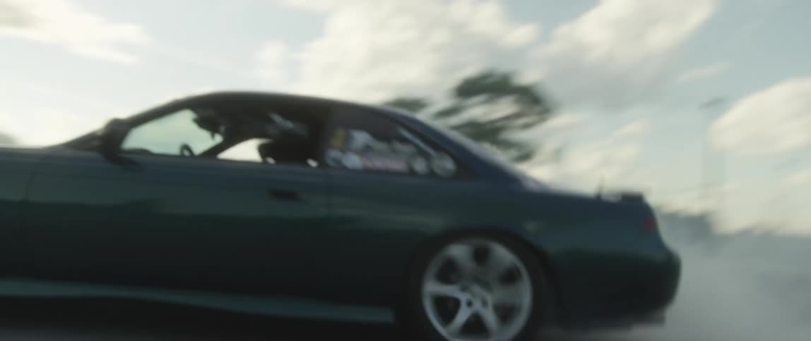 Dark sports car speeding and braking on a gravel road