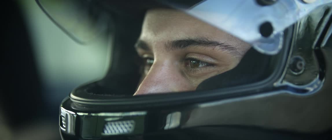 A man is wearing a black helmet with the visor up