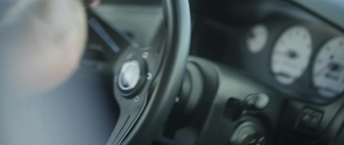 A person driving a fast car turning the steering wheel