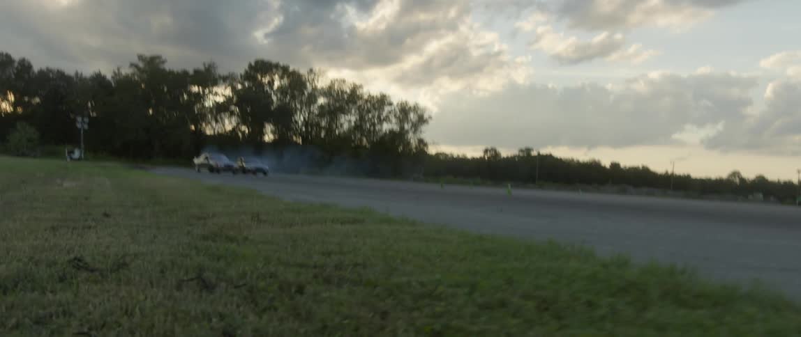 Two sports cars racing in a lot in the evening
