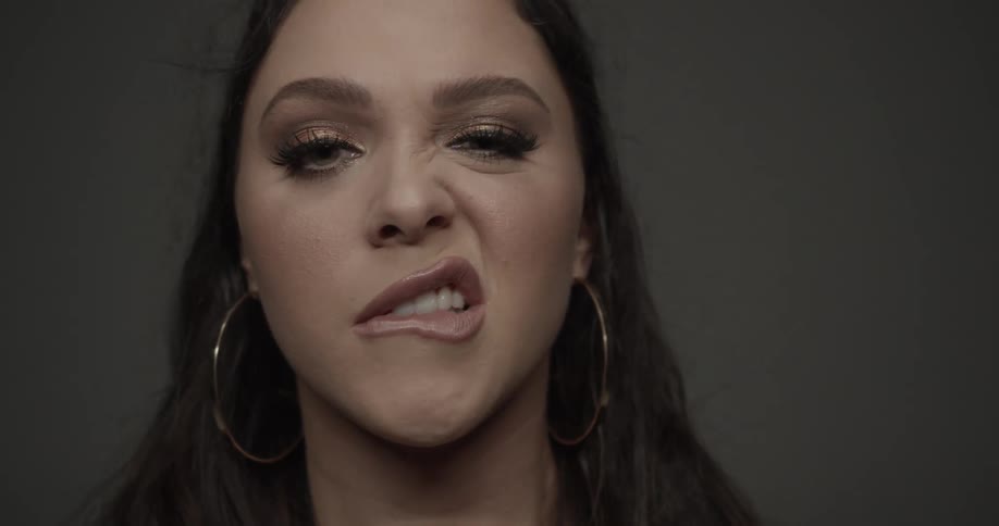 A close up of a woman biting her lip and making other facial expressions