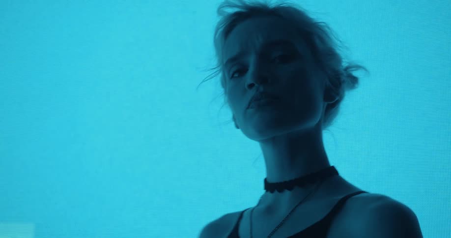 A close up of a woman with a color changing background