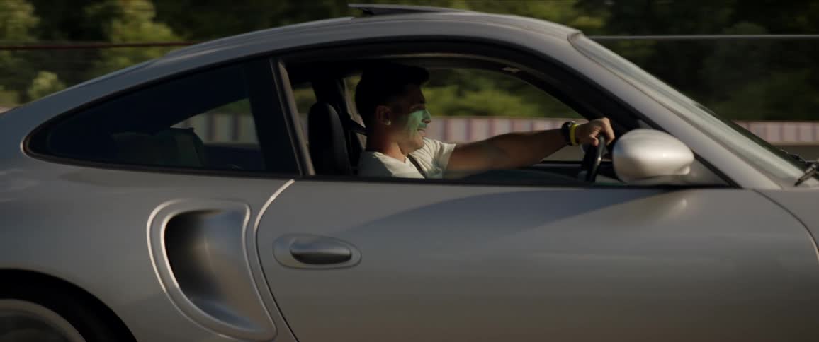 Man driving a coupe sports car in a road at full speed