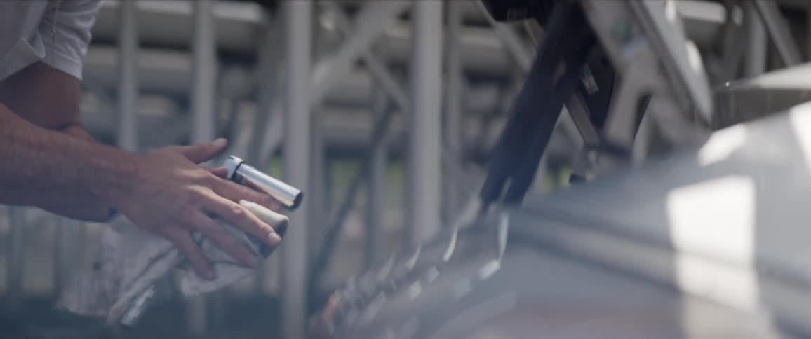 A man tightens a bolt under the hood of his car