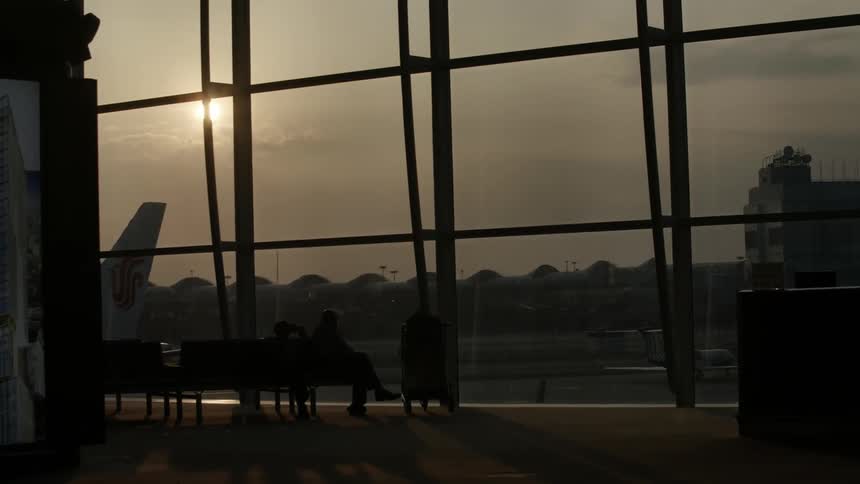 Passengers seated in an airport waiting area