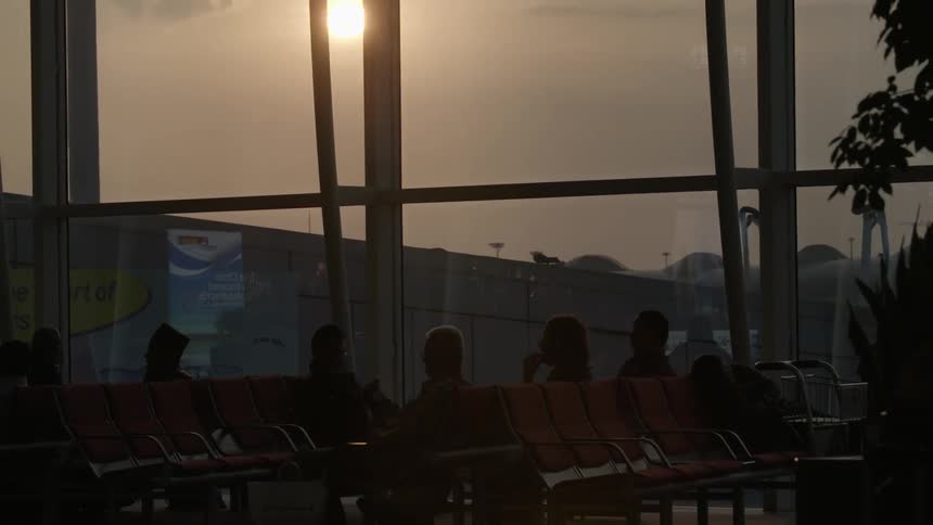 People walking through, or seated in, an airport waiting area