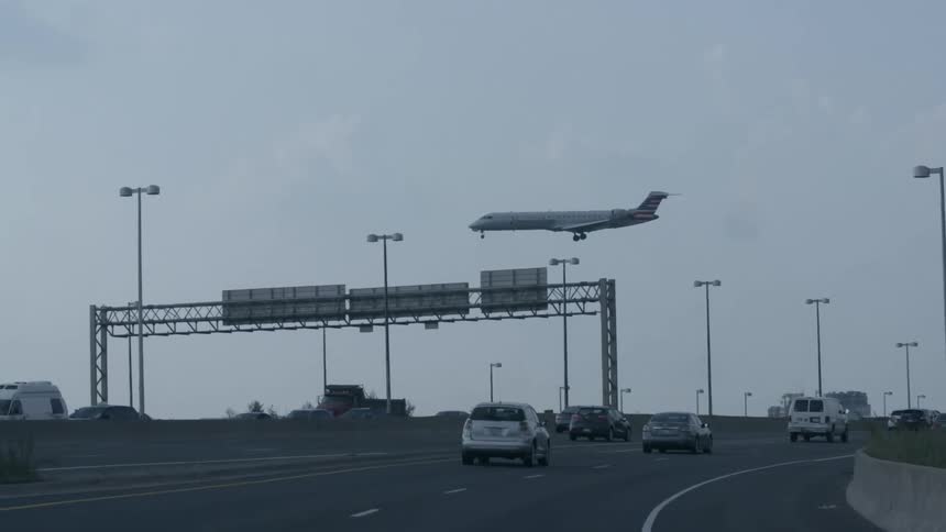 A low flying plane passes over a highway