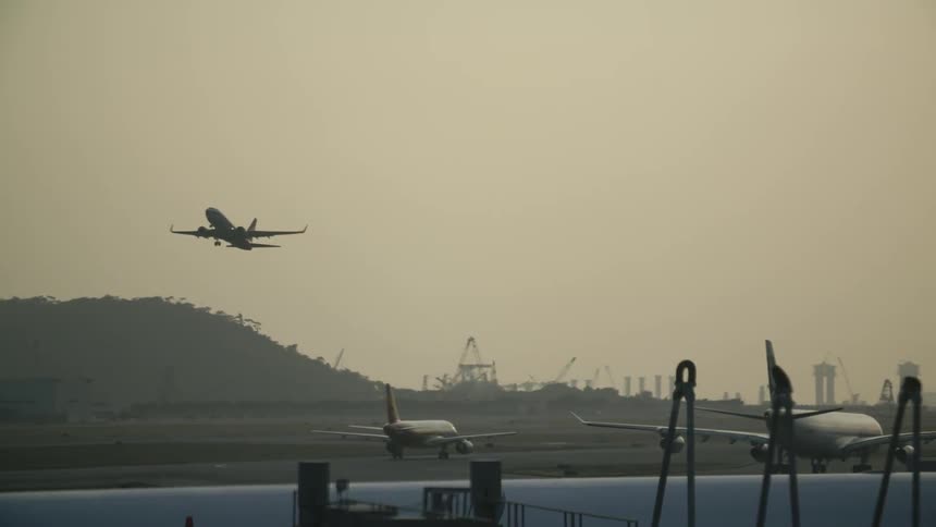 Planes are taking off from a runway at sunset