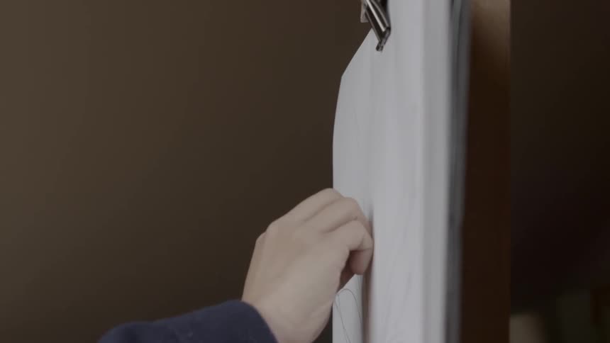A person is drawing with charcoal on a canvas