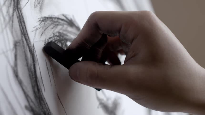 A man sketching with charcoal