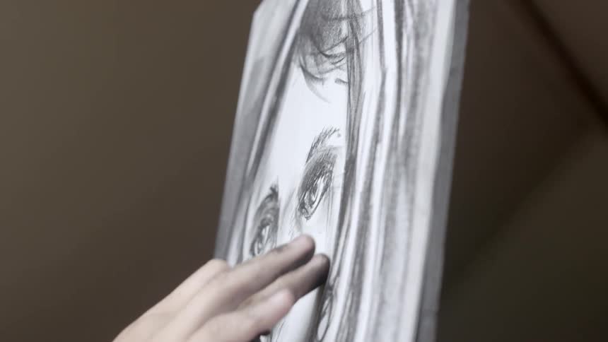 Person drawing a portrait with charcoal