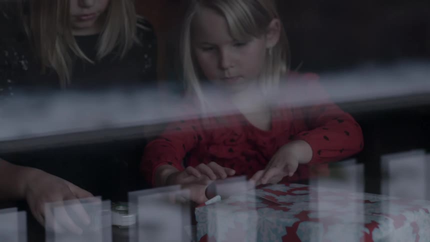 Two little girls wrapping a present