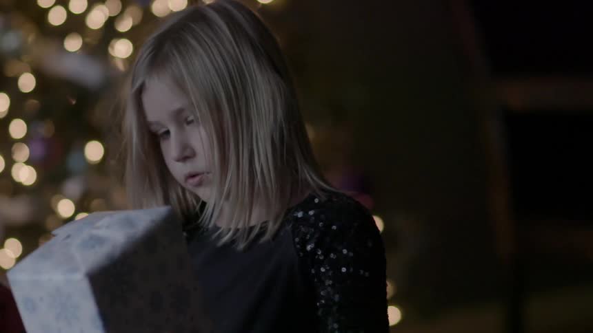 A young girl examines a present