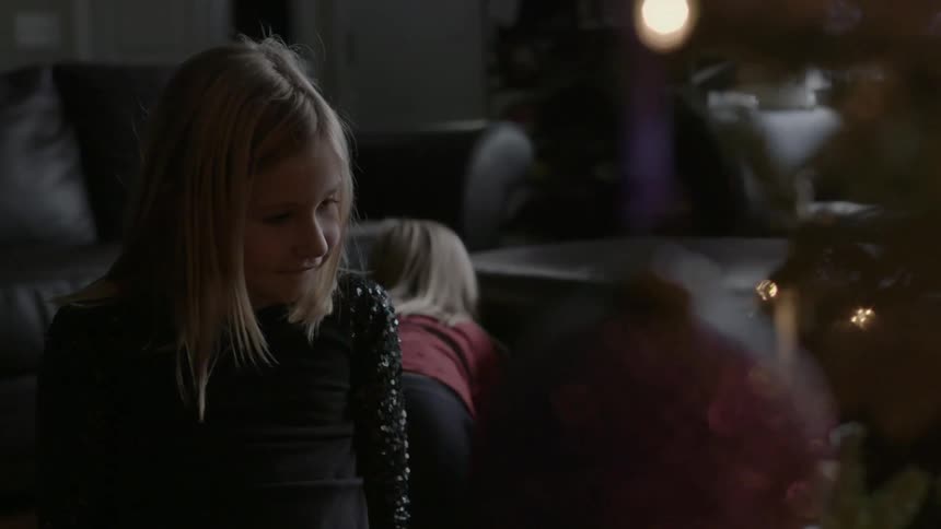 A little girl looking at ornaments on a christmas tree