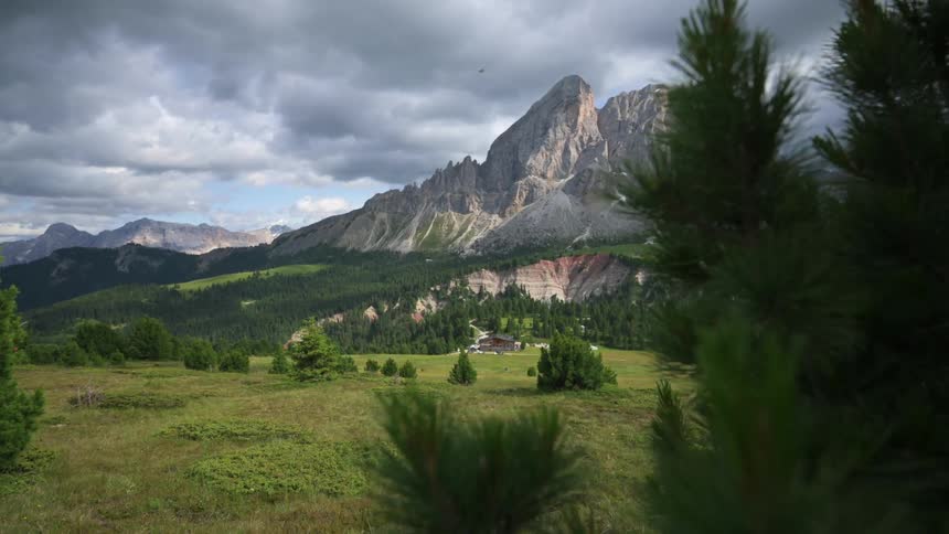 A large rocky mountain looms above a resort in the mountains