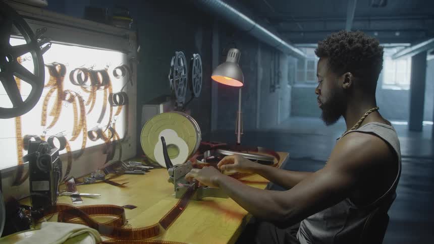 A man threads a film strip in to a machine