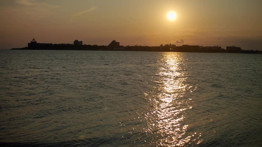 Horizon with a coastal city in front of the ocean at sunset