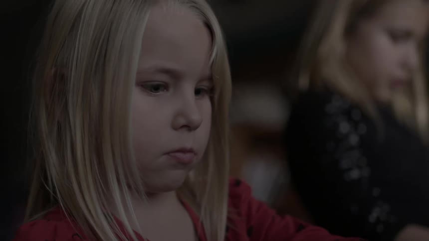 Little girl looking downwards with a fixated expression
