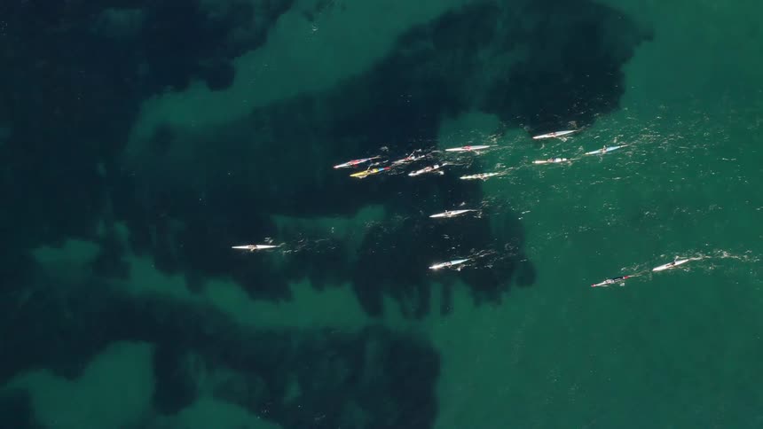 Aerial view of boats moving on the water above a reef