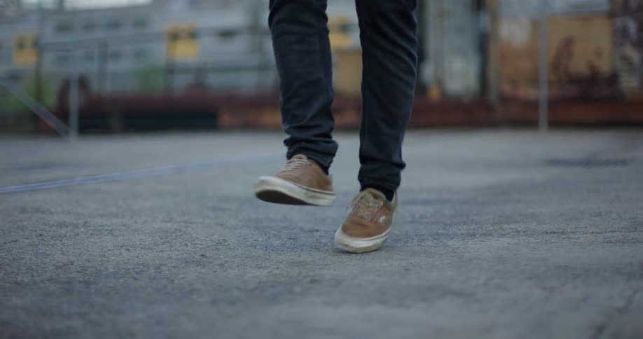 Man with black pants and brown shoes jumps rope in the train station