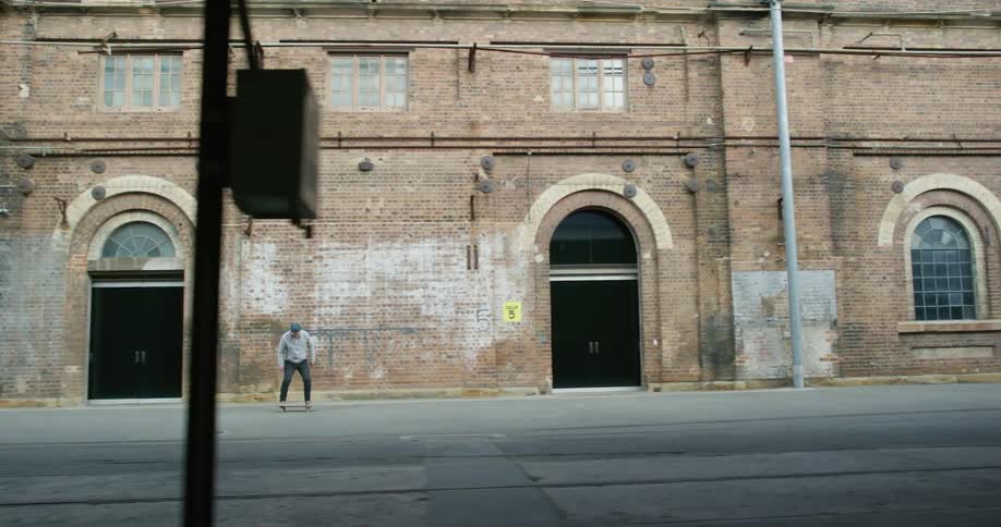 A man riding on a skateboard in the city on a sidewalk