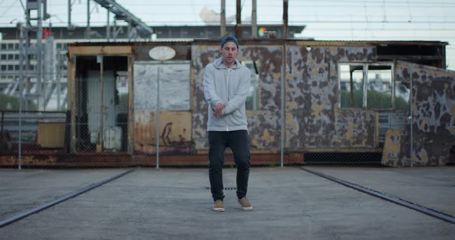 Man jumping rope in front of a dilapidated building in the city