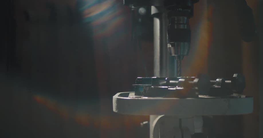 Electric drill on a mount inside a dimly lit workshop
