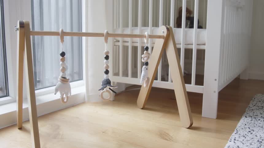 A baby toy next to a white crib in a nursery