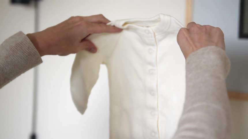 A woman is folding clothes indoors