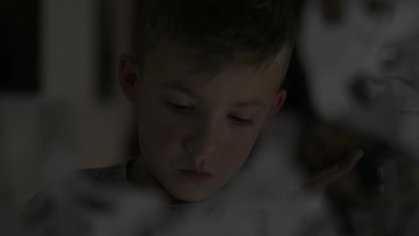 A young boy is looking downwards