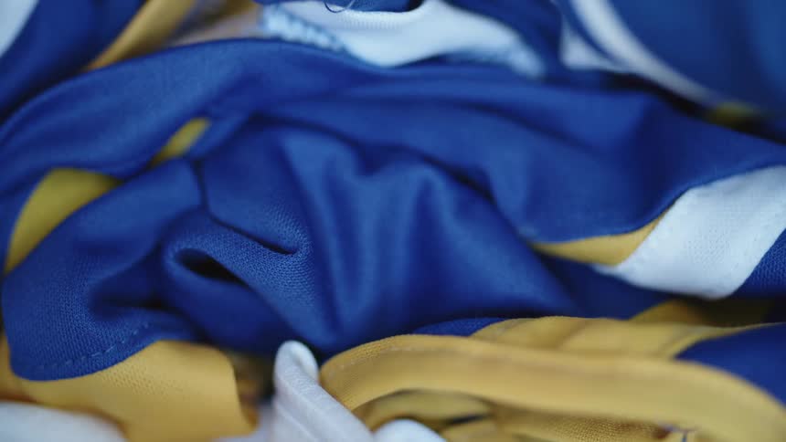 A pile of gold blue and white fabric indoors